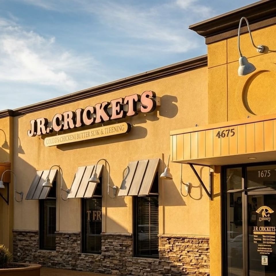 Exterior of J.R. Crickets restaurant, a yellow building with a prominent sign and awnings.