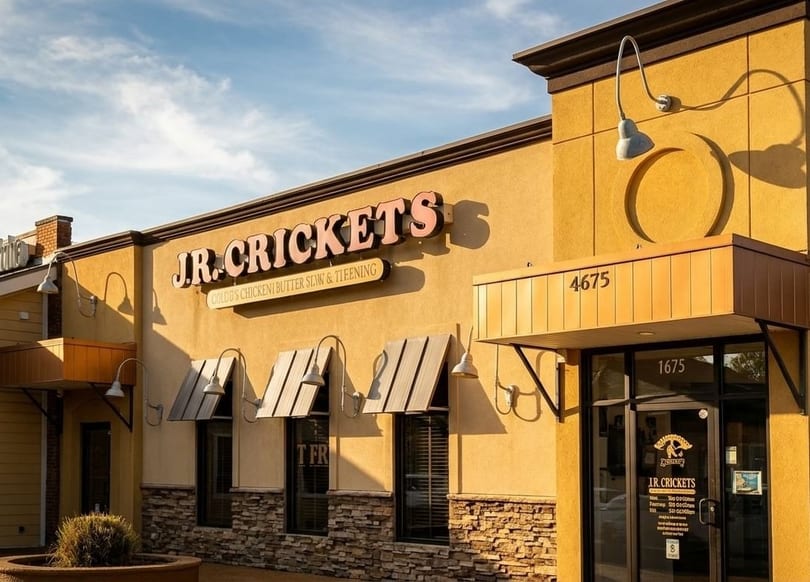 Exterior of J.R. Crickets restaurant, a yellow building with a prominent sign and awnings.